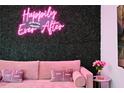 Comfortable living room with a pink sofa and a stylish neon light wall decoration at 3191 Paradox Cir # 401, Kissimmee, FL 34746