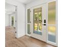 Bright entryway showcasing a stylish front door with decorative glass and sidelights, plus wood-look flooring at 345 W Hornbeam Dr, Longwood, FL 32779