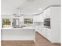 Modern kitchen features white cabinets, quartz countertops, stainless steel appliances, and peninsula seating at 345 W Hornbeam Dr, Longwood, FL 32779