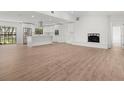 Open-concept living space boasts new floors, white brick fireplace and flows seamlessly into a modern white kitchen at 345 W Hornbeam Dr, Longwood, FL 32779