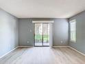 Open living room with sliding glass doors to the exterior and wood grain flooring at 3700 Idlebrook Cir # 114, Casselberry, FL 32707