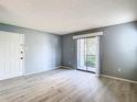 Open living room area with sliding glass doors to the exterior and wood grain flooring at 3700 Idlebrook Cir # 114, Casselberry, FL 32707