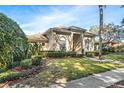 Well-maintained home featuring lush landscaping, a circular driveway, and a welcoming entrance at 418 Curry Ct, Altamonte Springs, FL 32714