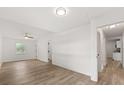 Large bedroom with ceiling fan, wood-look flooring, and hallway access to a bathroom and kitchen at 4246 Clarinda St, Orlando, FL 32811