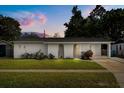 Charming home featuring arched entryways, well-maintained lawn, and mature landscaping at 4246 Clarinda St, Orlando, FL 32811