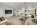 Bright, open-concept living room features tile flooring and flows seamlessly into the modern, updated kitchen at 4443 Doris Dr, New Smyrna Beach, FL 32169