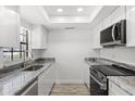 Well-lit kitchen featuring granite countertops, modern appliances, and sleek white cabinets at 500 Newell Hill Rd # 113A, Leesburg, FL 34748