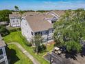 Exterior angle showing a well maintained condo with mature trees and landscaping at 5144 City St # 211, Orlando, FL 32839
