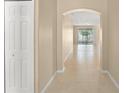 Bright hallway with neutral paint, tile flooring, and an archway leading to the living area at 558 Knollwood Dr, Davenport, FL 33837