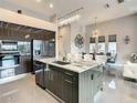 Gourmet kitchen features stainless steel appliances, marble countertop, and a chandelier in an open-concept layout at 748 Desert Mountain Ct, Reunion, FL 34747