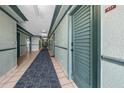 Long hallway with access to multiple units, featuring tile floors, neutral walls, and a blue carpet for noise reduction at 800 N Atlantic Ave # 417, Daytona Beach, FL 32118