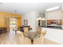 Open-concept dining area showcasing wood-look floors, modern lighting, and a seamless transition to the inviting living area at 8100 Poinciana Blvd # 2109, Orlando, FL 32821