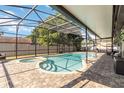 Inviting screened-in pool area with a spa, a paved patio, and comfortable seating, perfect for relaxation at 9338 Palm Tree Dr, Windermere, FL 34786
