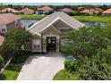 Beautiful aerial view of a beige home featuring a tile roof, brick driveway, and well-maintained landscaping at 1027 Algare Loop, Windermere, FL 34786