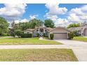 Inviting single-story home with a well-maintained lawn and garden beds, showcasing its charming curb appeal at 1034 Featherstone Cir, Ocoee, FL 34761