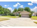 Attractive single-story home featuring manicured landscaping, healthy green lawn, and a convenient two-car garage at 1034 Featherstone Cir, Ocoee, FL 34761
