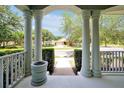View from the front porch featuring white columns, a brick path, and lush landscaping at 14522 Old Thicket Trace, Winter Garden, FL 34787