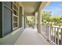 Spacious front porch with white railings and columns, offering a view of the landscaped yard at 14522 Old Thicket Trace, Winter Garden, FL 34787