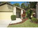 Inviting home entrance with a stone-accented porch, lush landscaping, and a well-manicured lawn at 1512 Southwind Ct, Casselberry, FL 32707