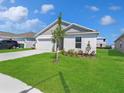 Well maintained lawn and landscaping of a one-story home with a two-car garage at 1649 Teagan Ln, Winter Haven, FL 33884