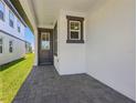 Inviting covered entrance with a glass paneled door and decorative gray trim at 1900 Archer Dr, Minneola, FL 34715