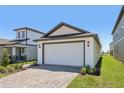 Charming home with a white garage door and an inviting paver driveway and walkway at 1900 Archer Dr, Minneola, FL 34715