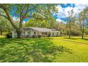 Traditional home with a well-manicured lawn, mature trees, and a welcoming facade at 20 Stone Gate S, Longwood, FL 32779