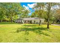 Inviting single-story home boasts lush lawn, mature trees, and a well-maintained landscape at 20 Stone Gate S, Longwood, FL 32779