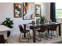 Inviting dining room featuring modern decor, a dark wood table, and contemporary artwork at 2030 Firethorn Loop, Haines City, FL 33844