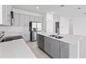 Modern kitchen featuring stainless steel appliances, gray cabinets, and a large island with a double sink at 2030 Firethorn Loop, Haines City, FL 33844