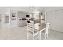 Bright kitchen featuring gray cabinets, stainless appliances, and tile floors; a table with chairs is at the forefront at 30 Sunset Cir, Lake Alfred, FL 33850
