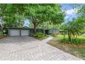 Traditional green home featuring a brick paver driveway and well-manicured landscaping at 3225 Hargill Dr, Orlando, FL 32806