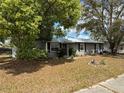 Charming single-story home with gray exterior paint, manicured landscaping, and mature shade trees at 3845 Sw 148Th Pl, Ocala, FL 34473