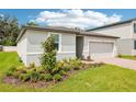 Well-maintained one-story home showcasing a two-car garage, landscaped yard, and neat lawn at 4701 Jasmine Cir, Leesburg, FL 34748