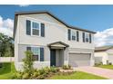 Charming two-story home featuring a two-car garage, beautiful landscaping and blue shutters at 4705 Jasmine Cir, Leesburg, FL 34748