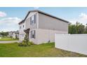 Two-story home with gray siding, white trim, well-maintained lawn, and a partially fenced yard at 4721 Jasmine Cir, Leesburg, FL 34748
