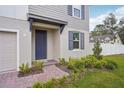 Charming front entrance with a blue front door, manicured landscaping, and a brick walkway at 4721 Jasmine Cir, Leesburg, FL 34748