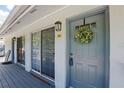 Condo entrance with storm door, door wreath, unit number, lighting fixture and sliding glass door at 4870 Conway Rd # 106, Orlando, FL 32812