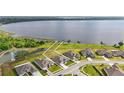 Stunning aerial view of home with lake access, dock, and expansive green lawn in a desirable community at 521 Sanctuary Blvd, Winter Haven, FL 33881