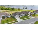 Aerial shot of a well-kept home with a lush lawn near a serene lake and neighboring properties at 521 Sanctuary Blvd, Winter Haven, FL 33881