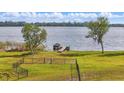 Scenic backyard view featuring a fenced yard, leading to a tranquil lake with a private dock at 521 Sanctuary Blvd, Winter Haven, FL 33881