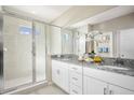 Modern bathroom featuring granite countertops, a dual sink vanity, and a glass-enclosed shower at 523 Silver Palm Dr, Haines City, FL 33844