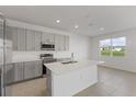 Bright kitchen with quartz countertops, stainless steel appliances, and an open layout leading to the dining area at 527 Silver Palm Dr, Haines City, FL 33844