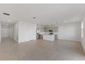 Open-concept living space with tile flooring and views of the modern kitchen, ideal for entertaining at 527 Silver Palm Dr, Haines City, FL 33844