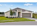 Attractive single-Gathering home with a two-car garage, landscaped front yard, and gray paver driveway at 531 Silver Palm Dr, Haines City, FL 33844