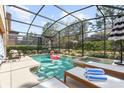 Private screened-in pool and spa area with lounge chairs, umbrella and an inflatable flamingo at 5416 Solterra Cir, Davenport, FL 33837