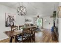Open-concept living room and dining area with modern furnishings and wood laminate flooring at 5831 Nw 58Th Ter, Ocala, FL 34482