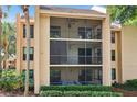 A three-story screened-in porch featuring seating and a ceiling fan to allow fresh air into the condo at 610 Cranes Way # 207, Altamonte Springs, FL 32701
