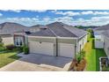 View of the home showing the two-car garage and the well manicured lawn at 7563 Sw 78Th Ter, Ocala, FL 34481