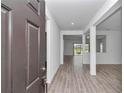 Bright foyer showcasing neutral paint, wood-look floors, and an open floor plan with high ceilings at 7563 Sw 78Th Ter, Ocala, FL 34481